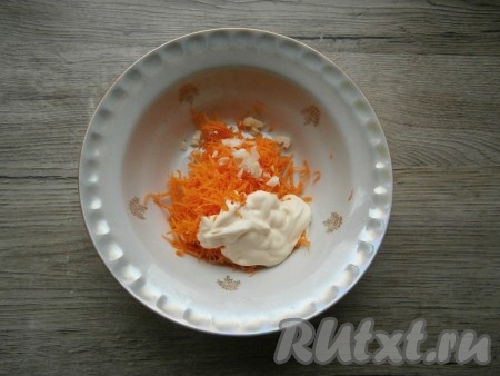 Очищенную свежую морковку натереть на мелкой терке, добавить измельченный чеснок и майонез, перемешать.
