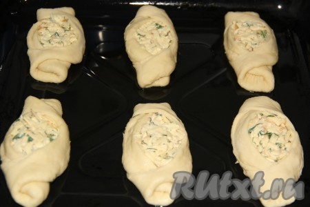 Готовые дрожжевые пирожки с сыром выложить на противень, предварительно смазанный растительным маслом. Оставить пирожки для расстойки на 30 минут.

