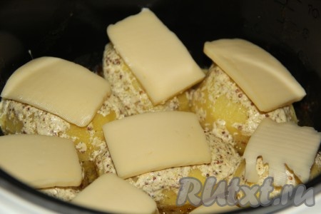 Через 30 минут открыть крышку мультиварки и выложить поверх каждой картофелины по кусочку сыра, закрыть крышку мультиварки и готовить на режиме "Выпечка" 20 минут.
