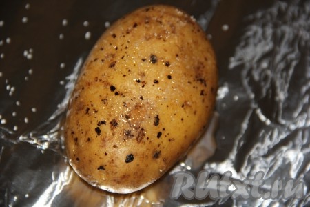 Каждую картофелину хорошо вымыть и, не очищая от кожуры, выложить на фольгу, сбрызнуть растительным маслом, посолить и поперчить.
