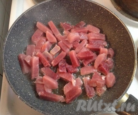 На сковороду наливаем подсолнечное масло и разогреваем. Выкладываем нарезанное мясо.
