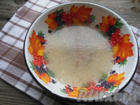 В глубокую миску насыпьте измельченный лук, добавьте соль, сахар, 3 столовые ложки растительного масла, влейте 0,5 литра кипятка, перемешайте.
