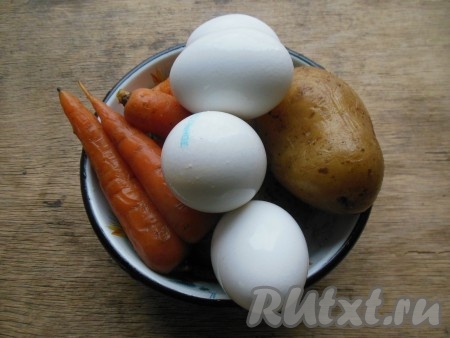 Картофель и морковь промойте под проточной водой, отварите в кожуре до готовности в несоленой воде. Продолжительность варки 30-35 минут (вареные овощи будут легко прокалываться ножом). Залейте вареные овощи холодной водой на несколько минут, затем воду слейте. Дайте картофелю с морковью полностью остыть. Куриные яйца сварите вкрутую в воде (в течение 8-10 минут с момента закипания). Затем горячую воду слейте, залейте яйца холодной водой и дайте им полностью остыть.
