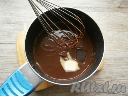 Добавить сливочное масло и кусочек черного шоколада. Подержать горячий шоколад на огне, перемешивая, до полного растворения масла и шоколада.
