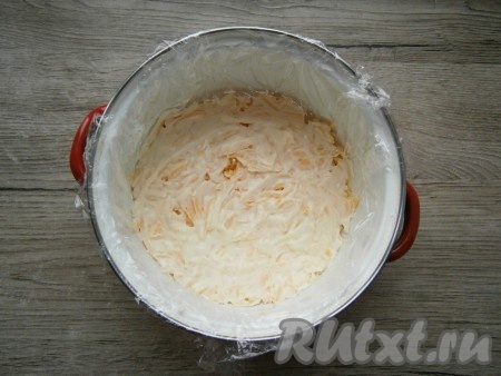 Полутвердый сыр натереть на крупной терке и выложить его нижним слоем, смазать майонезом. 