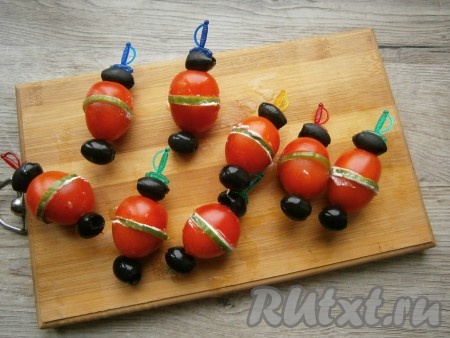 Нанизать каждый помидор на шпажку, разместив сверху и снизу помидорчика по оливке.
