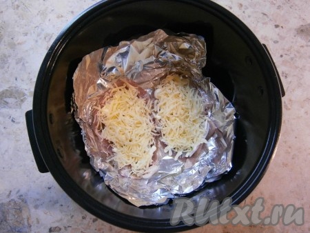 Щедро посыпать мясо натертым на средней терке сыром.
