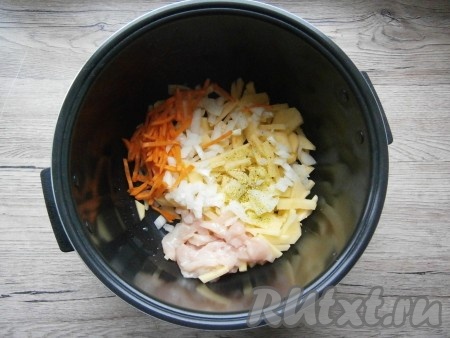 Картошку, морковь, лук и куриное мясо поместить в чашу мультиварки, влить растительное масло, всыпать приправу.
