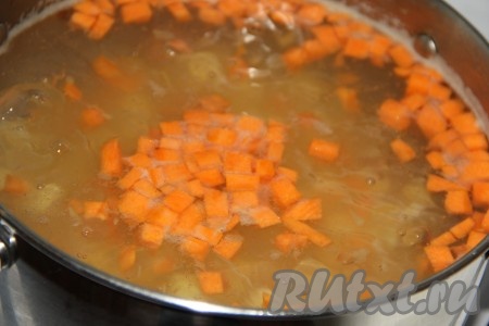 Как только вода с картошкой закипит, добавить в кастрюлю морковь и рис, довести до кипения и, уменьшив огонь, варить 10 минут.