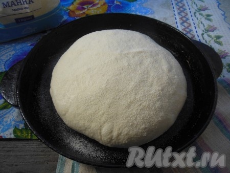 Переложите тесто в форму, верх теста присыпьте тонким слоем манной крупы. Я смазала руки растительным маслом и придала изделию круглую форму.
