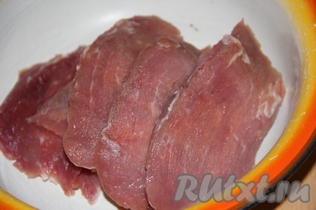 Свинину нарезать на ломтики толщиной 2-3 см. Выложить кусочки мяса в глубокую миску. По желанию, можно отбить мясо, я просто продавила его ладонью с двух сторон. 