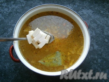 Дать супу со свининой закипеть, далее добавить нарезанный кусочками (или натертый на терке) плавленный сыр.
