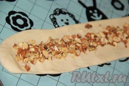 Орехи порубить ножом не очень мелко. Выложить орехи на вторую полоску из теста и сформировать вторую "колбаску", чтобы начинка оказалась внутри.
