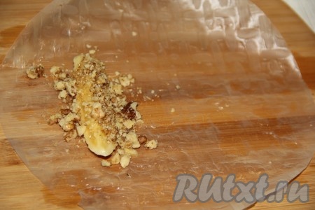Выложить на край листочка брусочек банана, посыпать орехами с сахаром.