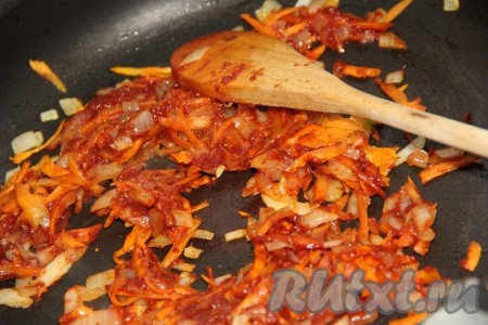 Затем к луку с морковкой добавить 1 столовую ложку томатной пасты, перемешать и обжарить в течение минуты.
