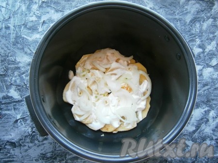 На дно чаши мультиварки влить растительное масло, затем выкладывать картофель слоями, пересыпая луком и смазывая сметаной.
