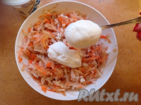 Соединяем дайкон, яблоко, морковь, чеснок и орехи в салатнике, солим, заправляем сметаной и хорошо перемешиваем.
