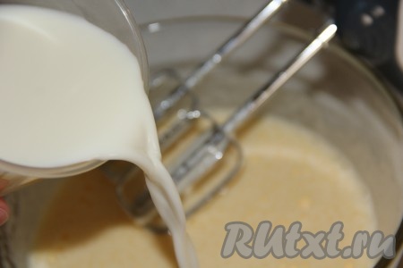 Затем влить в яичную массу тёплое молоко и перемешать миксером.