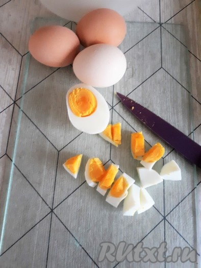 Яйца отварить вкрутую (в течение 10 минут с момента закипания воды), остудить, нарезать довольно крупно, выложить в миску.

