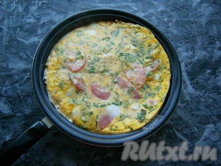 Сковороду накрыть крышкой и готовить омлет с кабачками и помидорами около 10-15 минут на минимальном огне. Сверху яйца не должны остаться жидкими.
