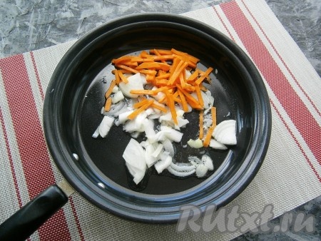 Очистить лук, чеснок и морковь. Нарезать произвольно репчатый лук, морковку нарезать соломкой и поместить в сковороду с растительным маслом.
