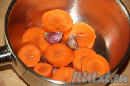 Морковь очистить, нарезать кружочками и вместе с зубчиками чеснока выложить в сотейник (или небольшую кастрюльку). Чеснок чистить не нужно, достаточно просто промыть под проточной водой.
