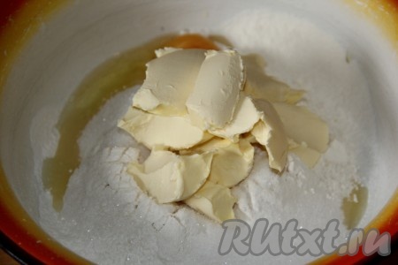 Масло заранее достать из холодильника, чтобы оно стало мягким. Для приготовления теста в миску просеять муку, добавить яйцо, сахар и кусочки мягкого сливочного масла.
