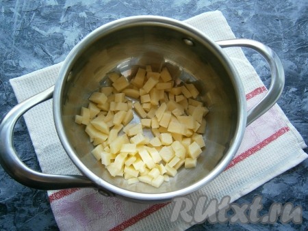 Картофель, морковь, чеснок и лук очистить, вымыть. Нарезать в кастрюлю картошку небольшими кубиками, залить водой, довести до кипения, посолить. Затем варить картофель на небольшом огне 15 минут.
