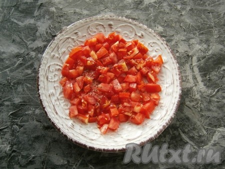 Твёрдые, но спелые помидоры нарезать кубиками, выложить на плоскую тарелку первым слоем, немного посолить и поперчить.