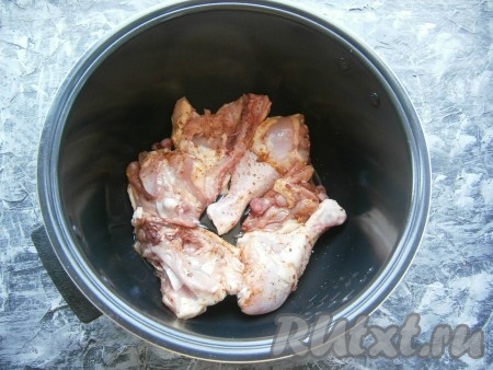 В чашу мультиварки влить растительное масло и выложить части курицы в один слой.
