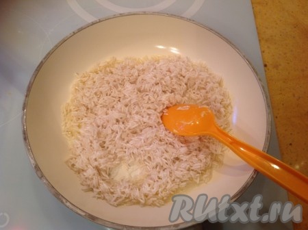 Высыпать рис на горячую сковородку и хорошо перемешать. 