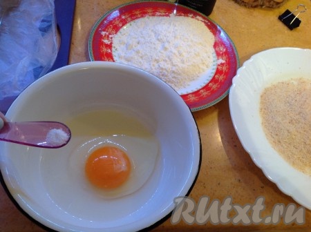 Для обваливания отбивных подготовим три тарелки - с мукой, с панировочными сухарями и с яйцом, которое надо посолить и слегка взбить вилкой.