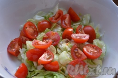 Помидоры черри порезать на половинки или четвертинки и добавить к порезанному салату.