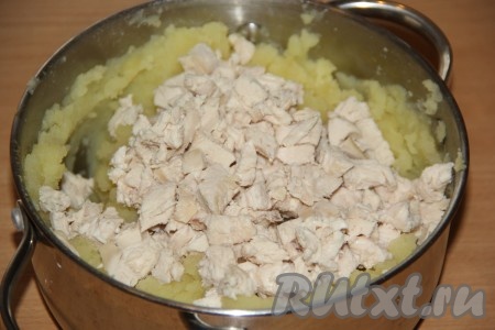 Отваренное куриное мясо нарезать на кусочки и добавить в горячее картофельное пюре.
