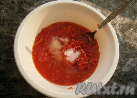 Помидоры вымыть, разрезать пополам и натереть на крупной тёрке так, чтобы кожица осталась в руках (её нужно выбросить). Можно помидоры залить кипятком на 3-5 минут, после чего снять кожицу и натереть их на тёрке или измельчить в блендере или мясорубке. К томатному пюре добавить измельчённый перец с чесноком, всыпать соль, сахар и влить уксус.
