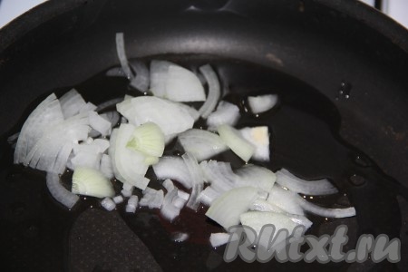 Нарезать очищенный лук тонкими полукольцами. Влить в сковороду немного масла и выложить нарезанный лук. 