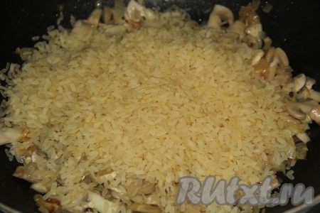 Жарить грибы до полного испарения жидкости (примерно, 10 минут), помешивая время от времени. Затем добавить рис. 