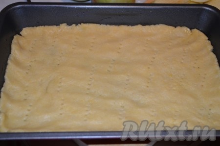 Готовое тесто для пирога тонко распределить по форме, наколоть вилкой.