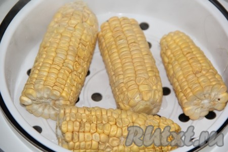 Разрезать кукурузу на 2 части и выложить на поддон для пароварки. Налить в чашу мультиварки достаточное количество воды, закрыть крышку мультиварки и готовить кукурузу на режиме "На пару" 30 минут.
