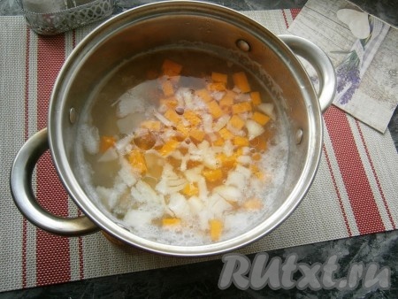 Когда картофель сварится до полуготовности, добавить в суп лук и тыкву, влить растительное масло, довести до кипения, уменьшить огонь.
