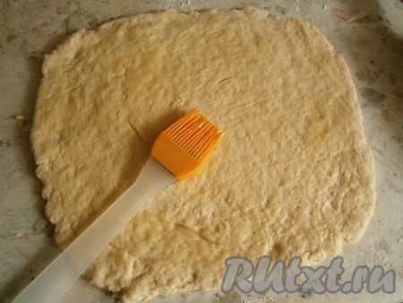 На столе, припылённом мукой, раскатать тесто в пласт толщиной около 0,5 см. Растопить и немного остудить 20-30 грамм сливочного масла и смазать им тесто.
