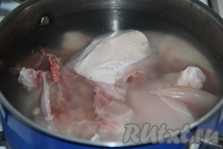 Выложить части цыплёнка в кастрюлю, залить 2,5 литрами воды, добавить пару лавровых листьев.
