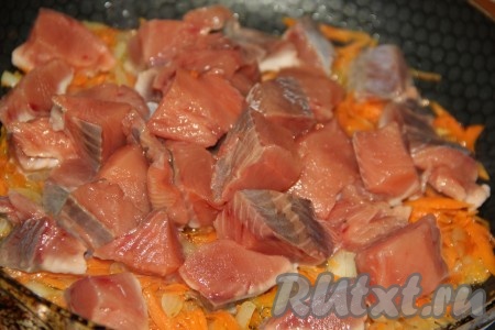 В сковороду, к обжаренным моркови и луку, добавить кусочки рыбы.
