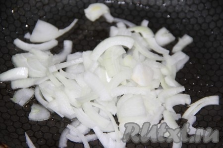 В сковороду влить растительное масло и выложить очищенный лук, нарезанный полукольцами.
