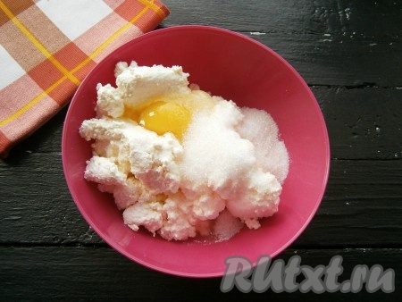 Для приготовления начинки в творог добавить одно яйцо. А второе яйцо разделить на белок и желток. Белок добавить в творог, желток оставить для смазывания булочек. Всыпать в творог сахар и ванильный сахар, тщательно перемешать. 