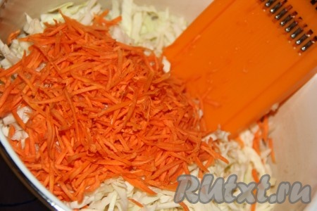 Натереть морковку на тёрке для корейской моркови и выложить в кастрюлю с капустой. 