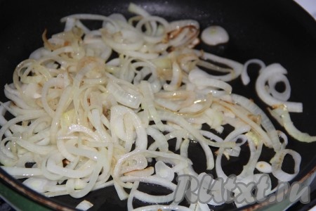 Для приготовления начинки лук, чеснок и морковь очистить. Нарезать лук на тонкие полукольца. В сковороду влить растительное масло, выложить лук и обжарить его в течение 3 минут, иногда помешивая, на среднем огне.
