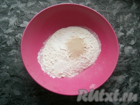 Для приготовления теста просеять в миску муку, добавить по щепотке соли и сахара, всыпать дрожжи, перемешать.
