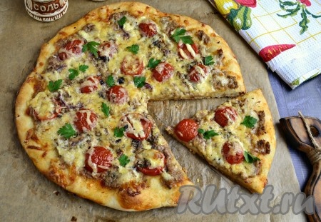 Ароматную, очень вкусную пиццу с консервированным тунцом нарезать на части и подать в горячем виде.