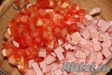 Вымыть помидоры, мелко нарезать и выложить к колбасе.
